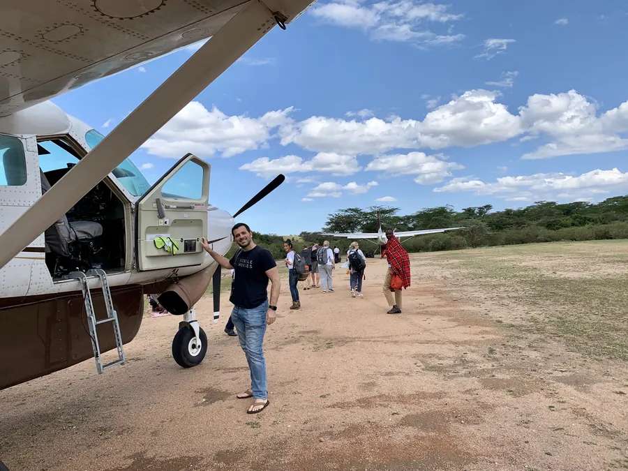 Dee’s husband beside a small plane on a dirt airstrip