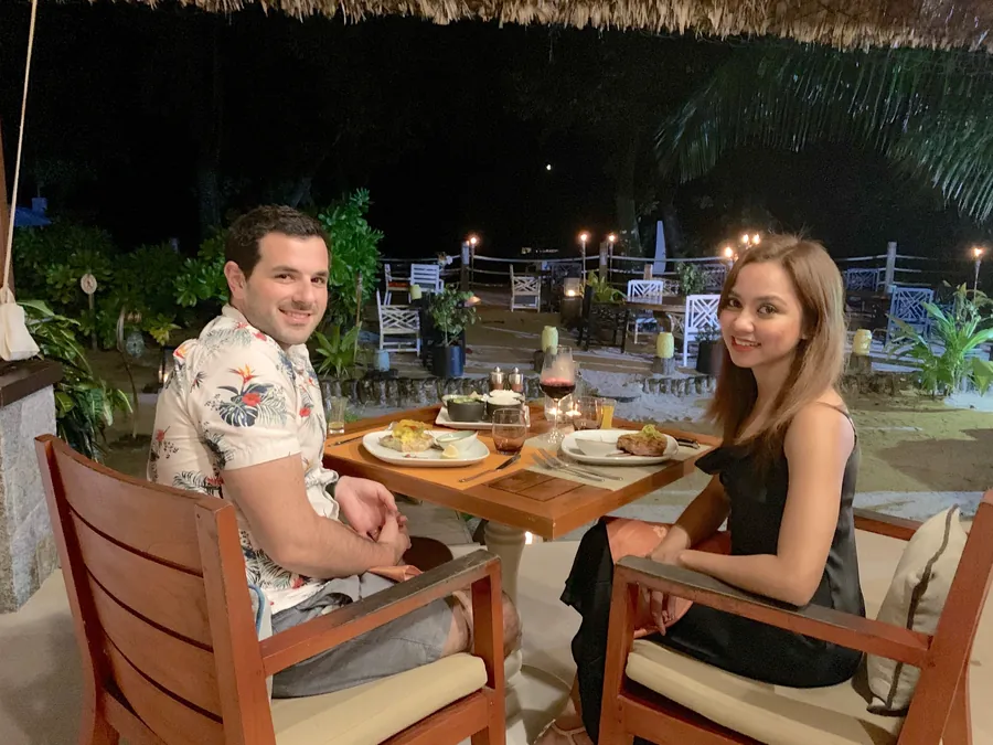 Dee and her husband at dinner by torchlight