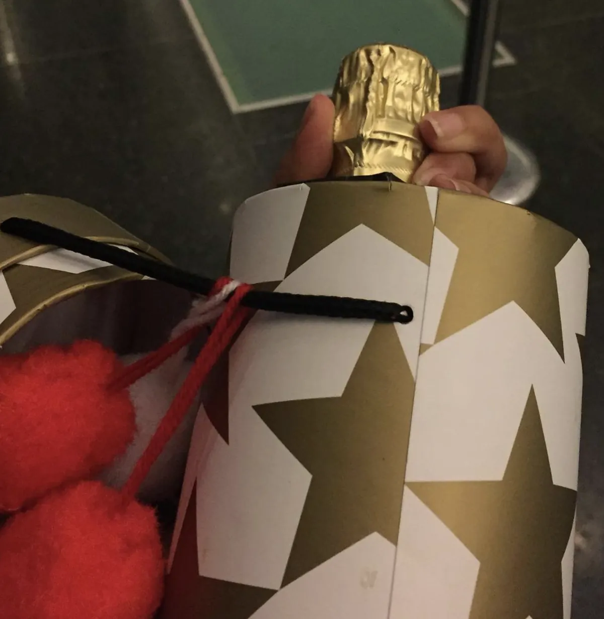 A bottle of bubbles in a gold star-print gift wrap