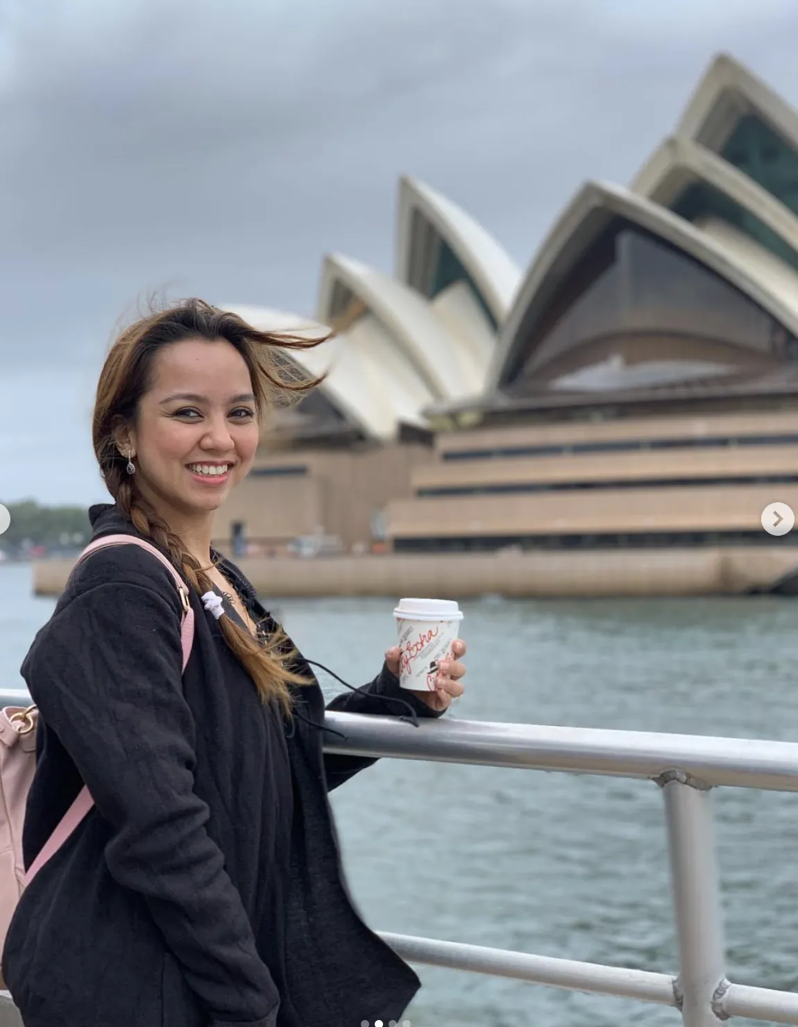 Dee with a coffee on a ferry in front of the Opera House