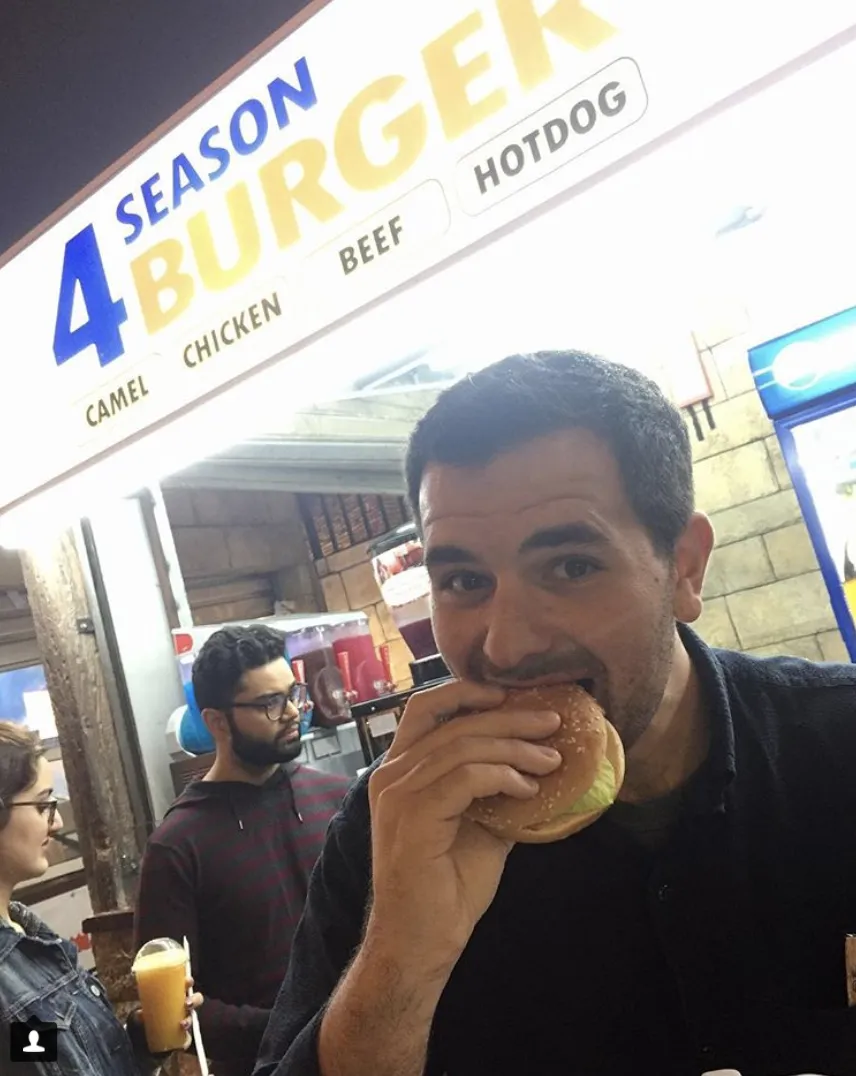 Oliver braving a camel burger at Global Village.