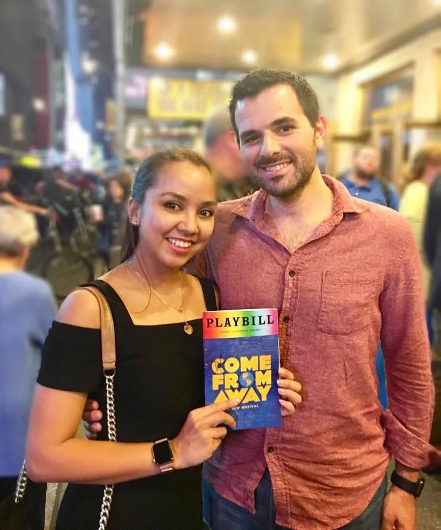Dee and her husband holding a Come From Away playbill