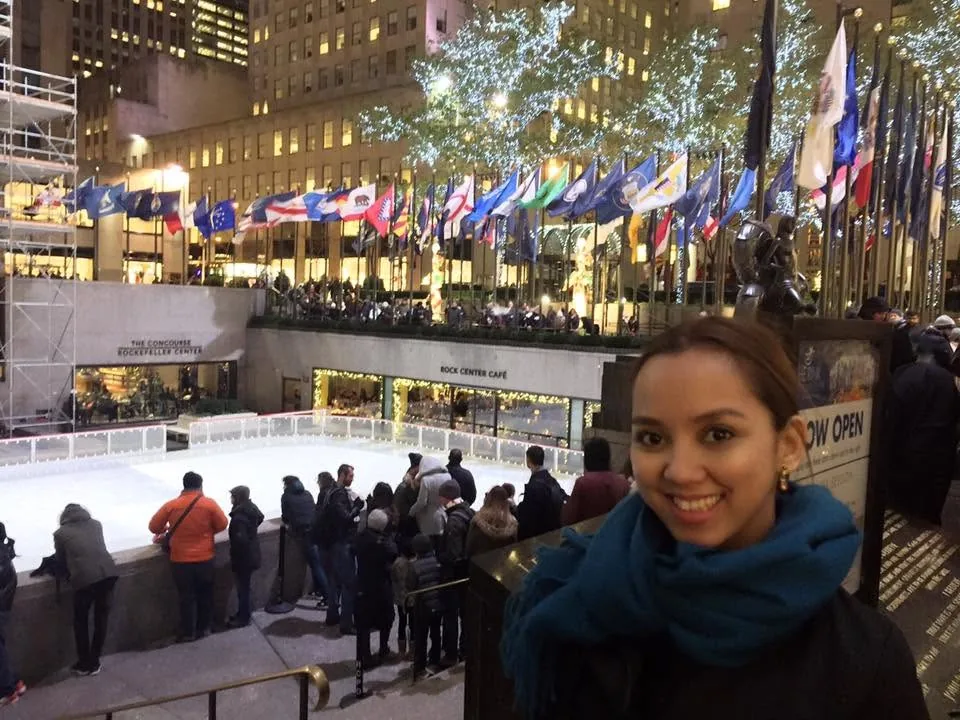 Dee in a blue scarf above the Rockefeller Center ice rink