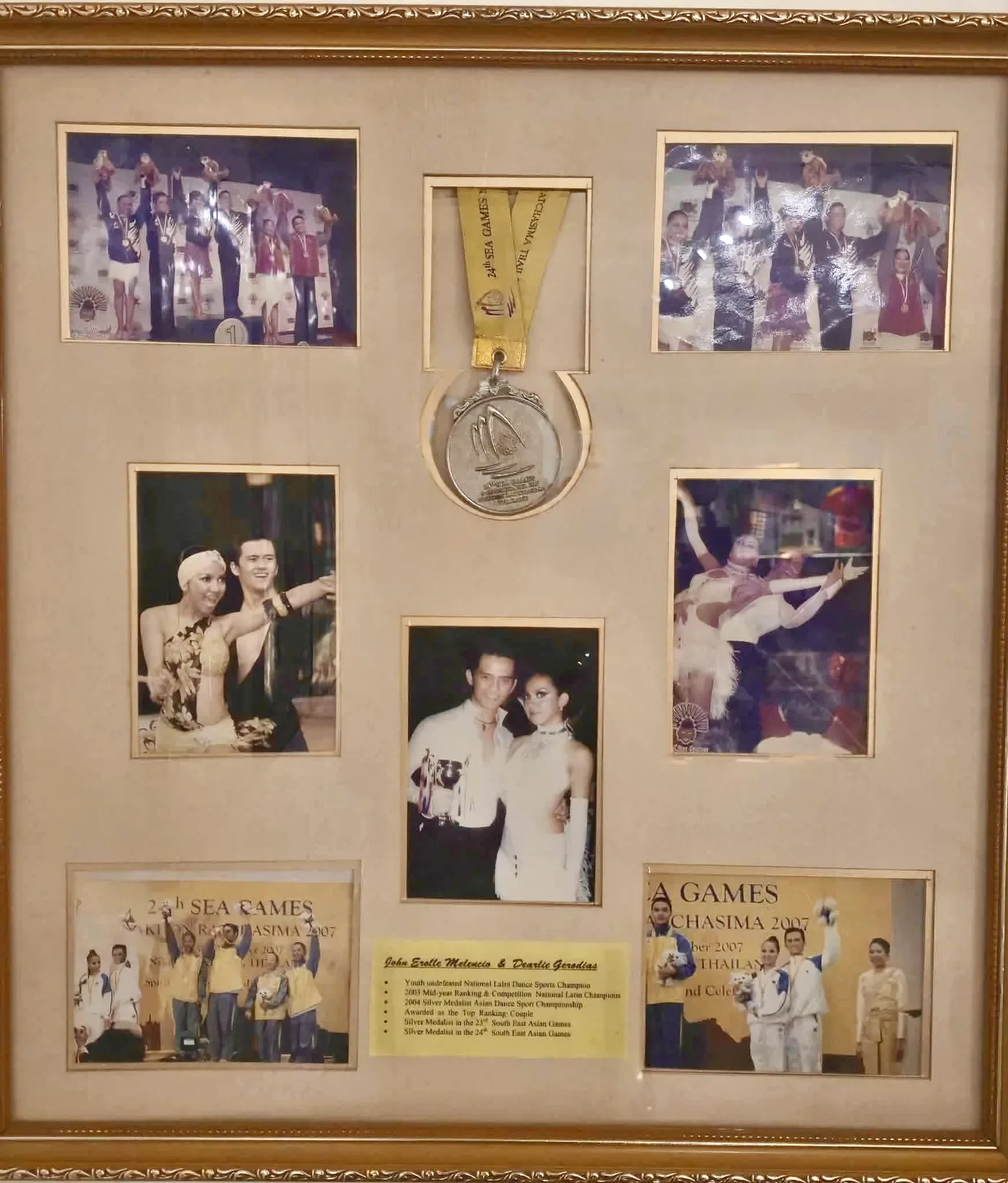 A gold frame holding a SEA Games 2007 silver medal and photos of Dee and John Erolle on podiums and dancing